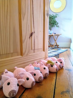 A draft excluder made from crochet pigs at the bottom of a door