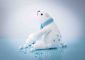 A crochet polar bear surrounded by snowballs