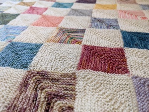 A knitted blanket of alternating squares